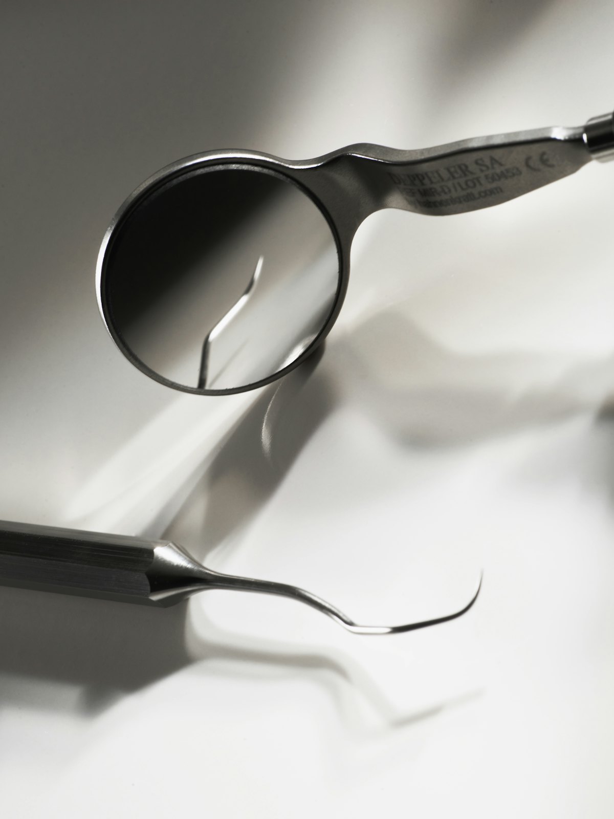 A dental mirror and explorer on a white tray